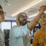 A diverse group of adults brainstorming on glass in a modern office setting.